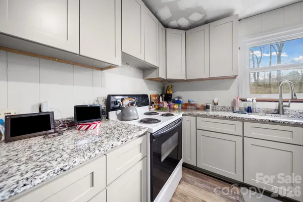 a kitchen with kitchen island granite countertop a sink a stove and cabinets