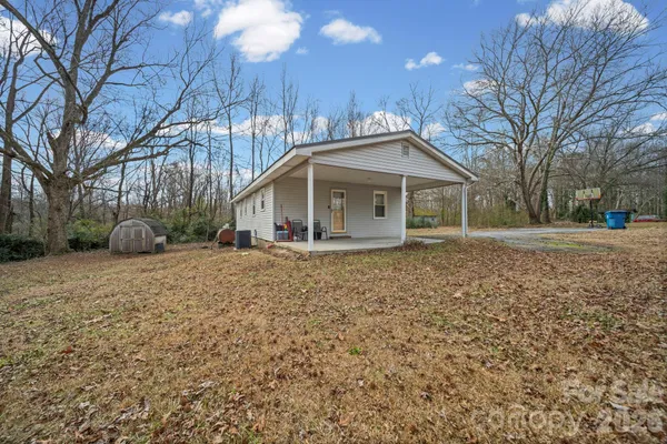 a front view of a house with a yard and trees