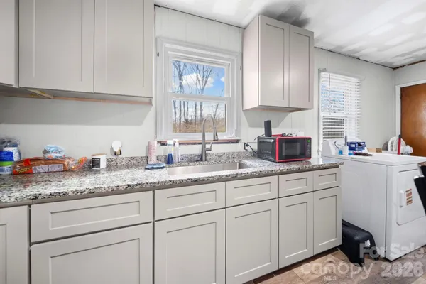 a kitchen with granite countertop white cabinets and white appliances