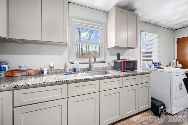 a kitchen with granite countertop white cabinets and white appliances