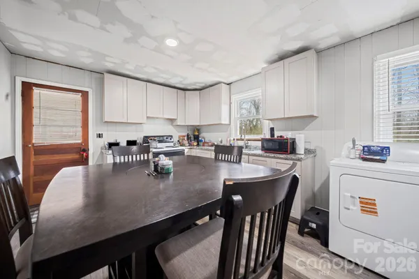 a kitchen with stainless steel appliances granite countertop a stove a sink a table and chairs