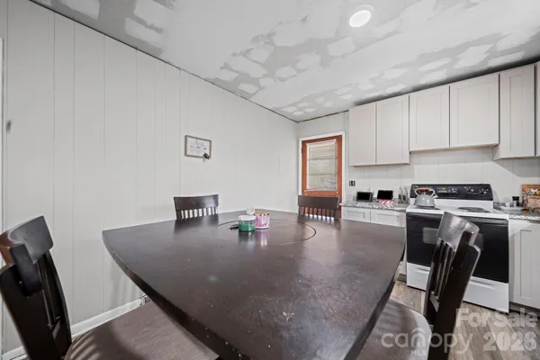 a kitchen with a dining table chairs and stove