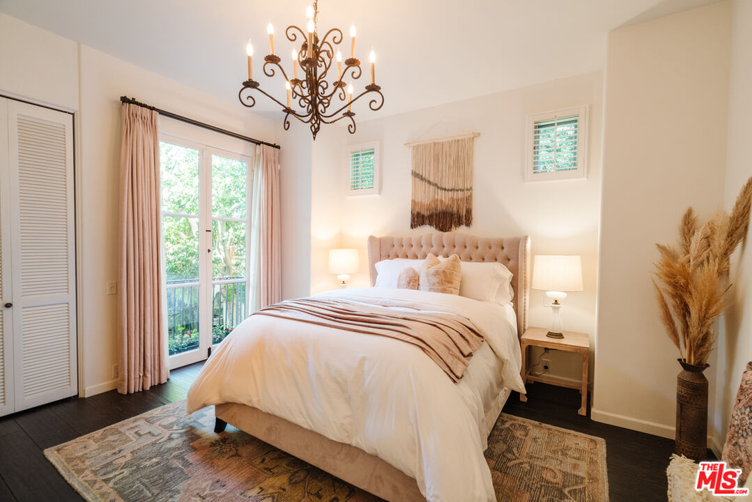 1636 Queens Road Los Angeles, CA 90069 - Photo 27 of 50 a bedroom with a large bed and a chandelier