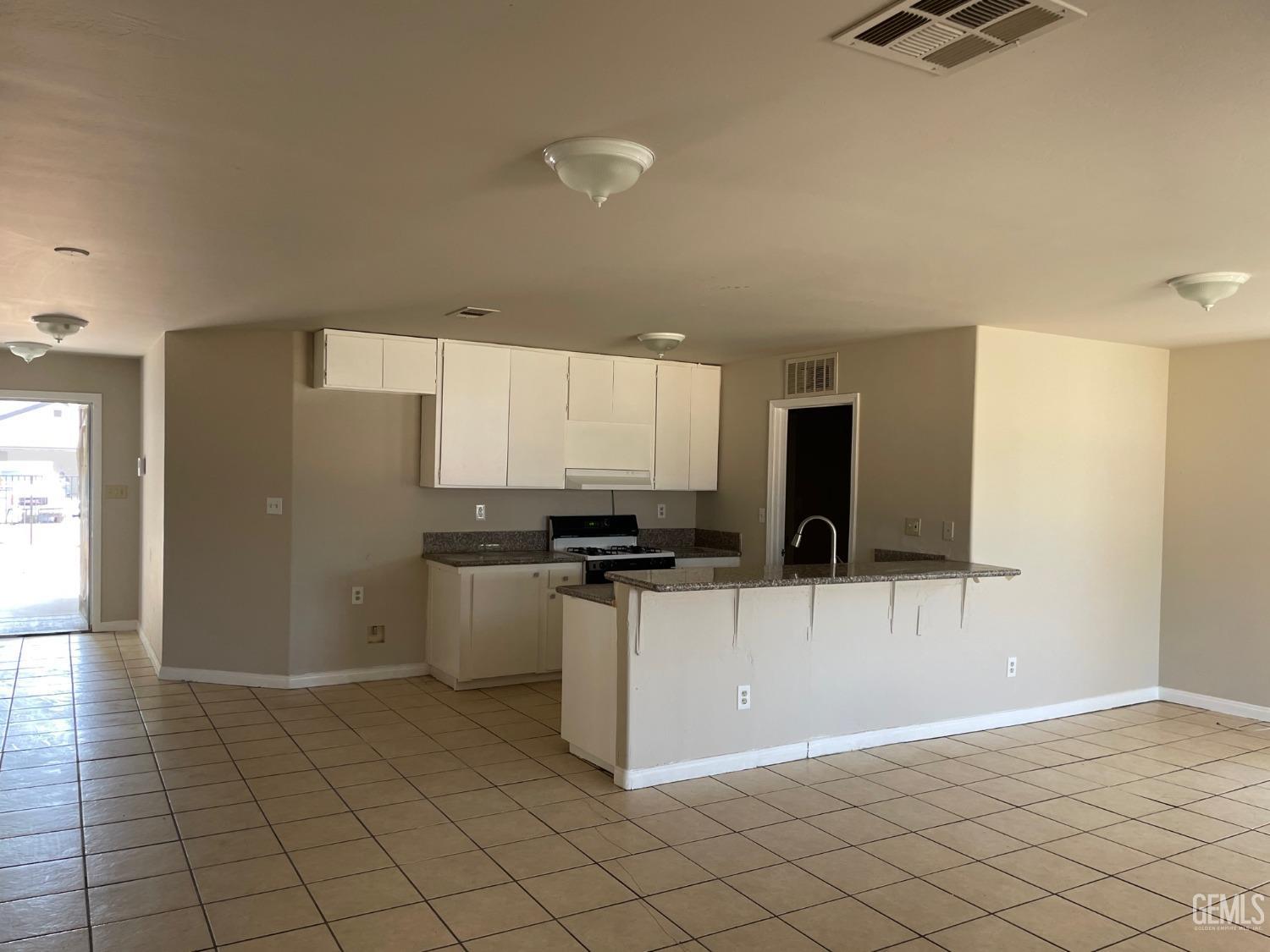 Undisclosed Address Bakersfield, CA 93307 - Photo 11 of 20 a kitchen with stainless steel appliances a stove a microwave a sink and cabinets