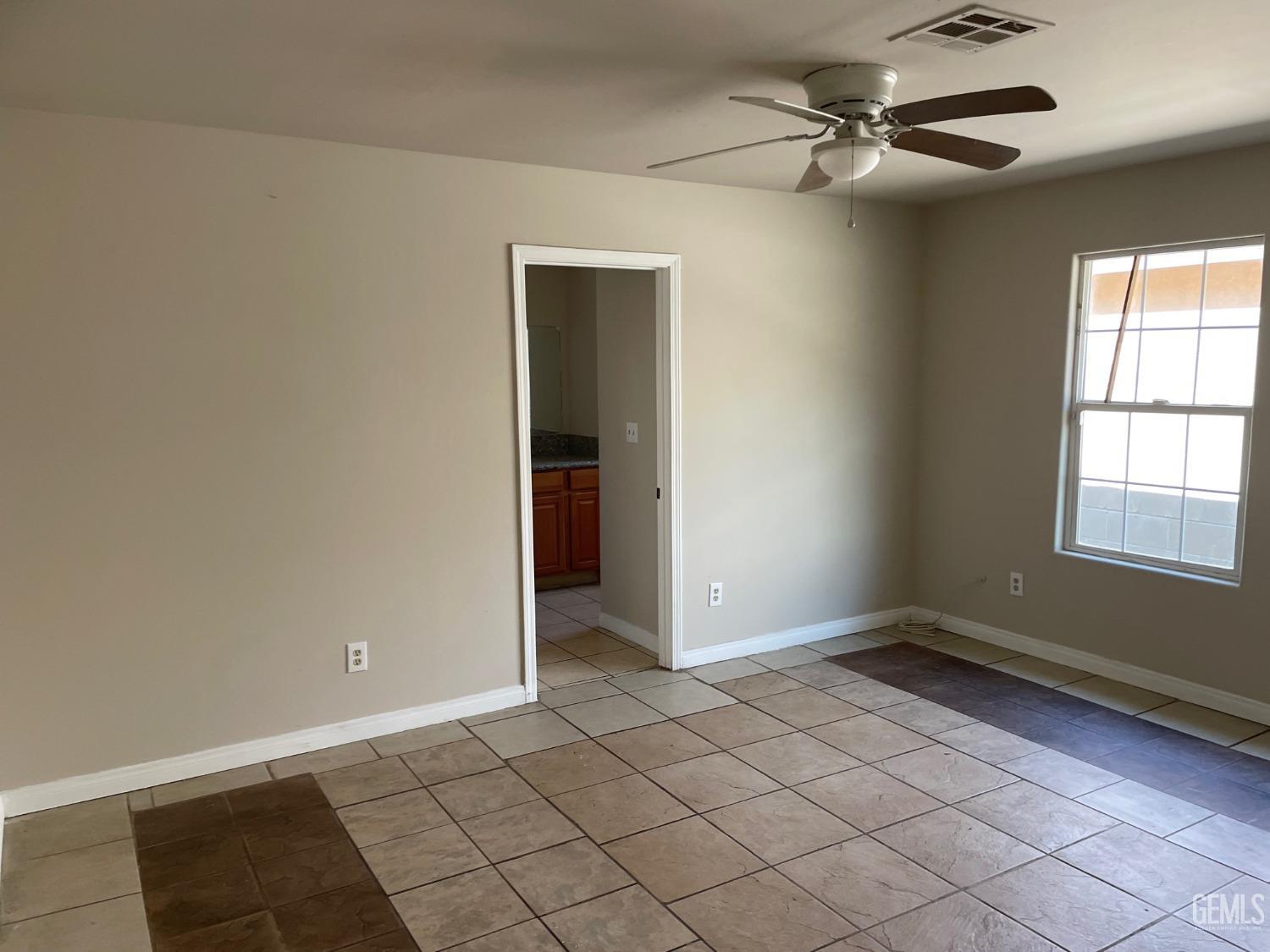 Undisclosed Address Bakersfield, CA 93307 - Photo 12 of 20 an empty room with windows and fan