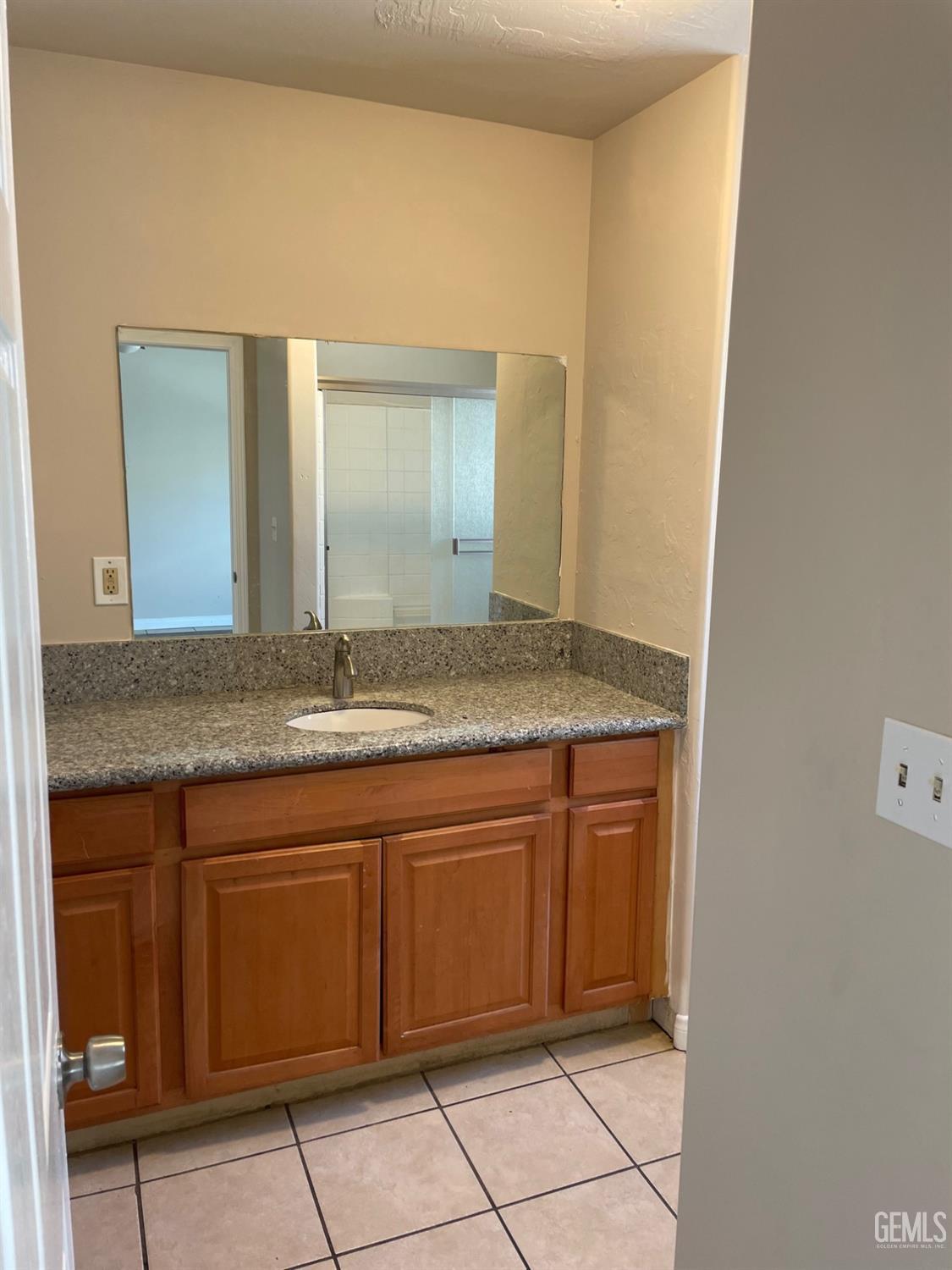 Undisclosed Address Bakersfield, CA 93307 - Photo 14 of 20 a bathroom with a granite countertop sink and a mirror
