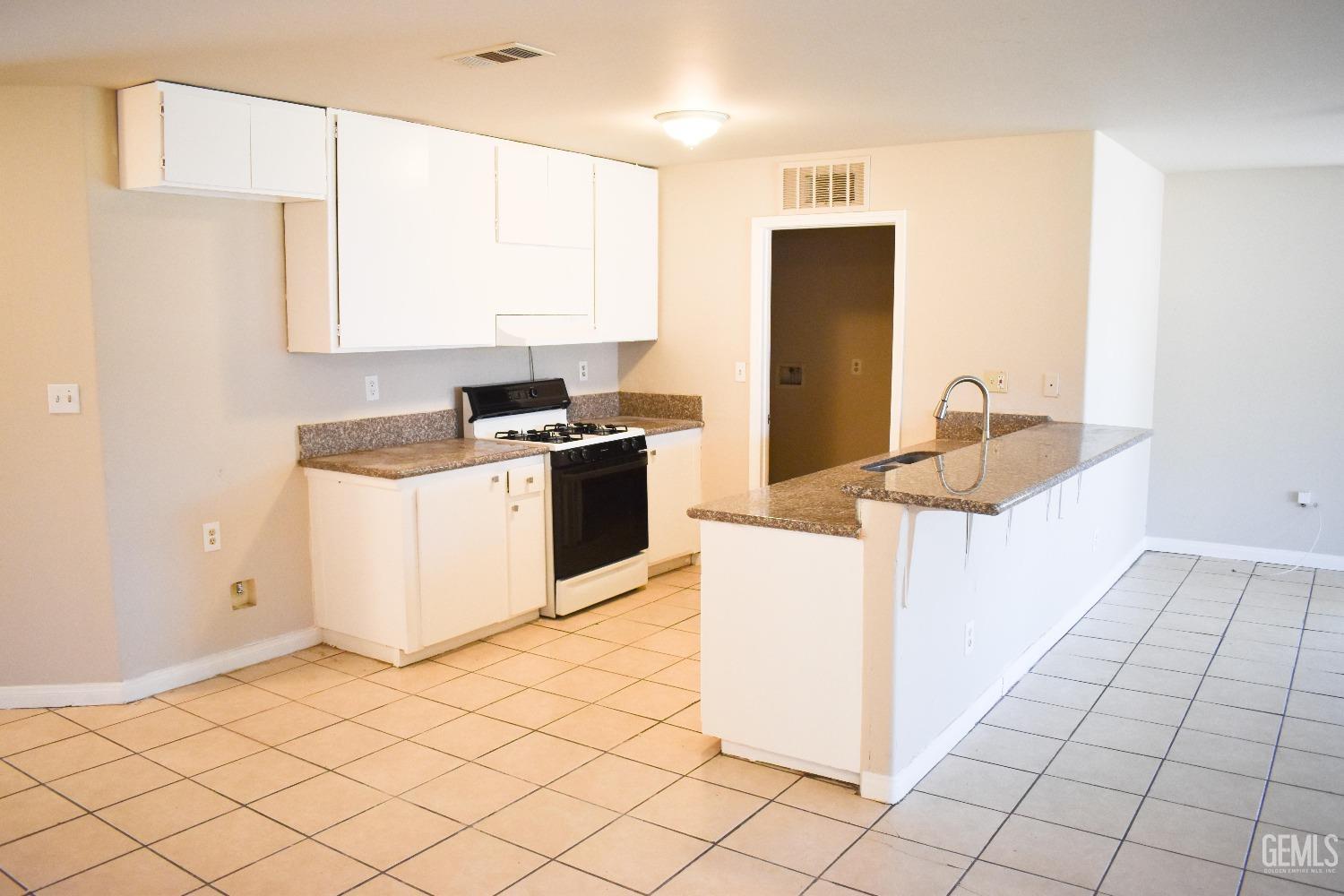 Undisclosed Address Bakersfield, CA 93307 - Photo 4 of 20 a kitchen with a sink cabinets and a stove top oven