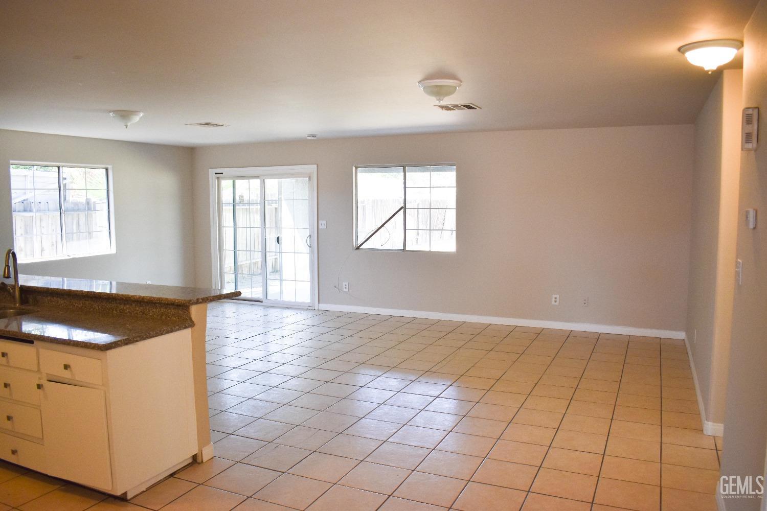 Undisclosed Address Bakersfield, CA 93307 - Photo 6 of 20 an empty room with windows and cabinet