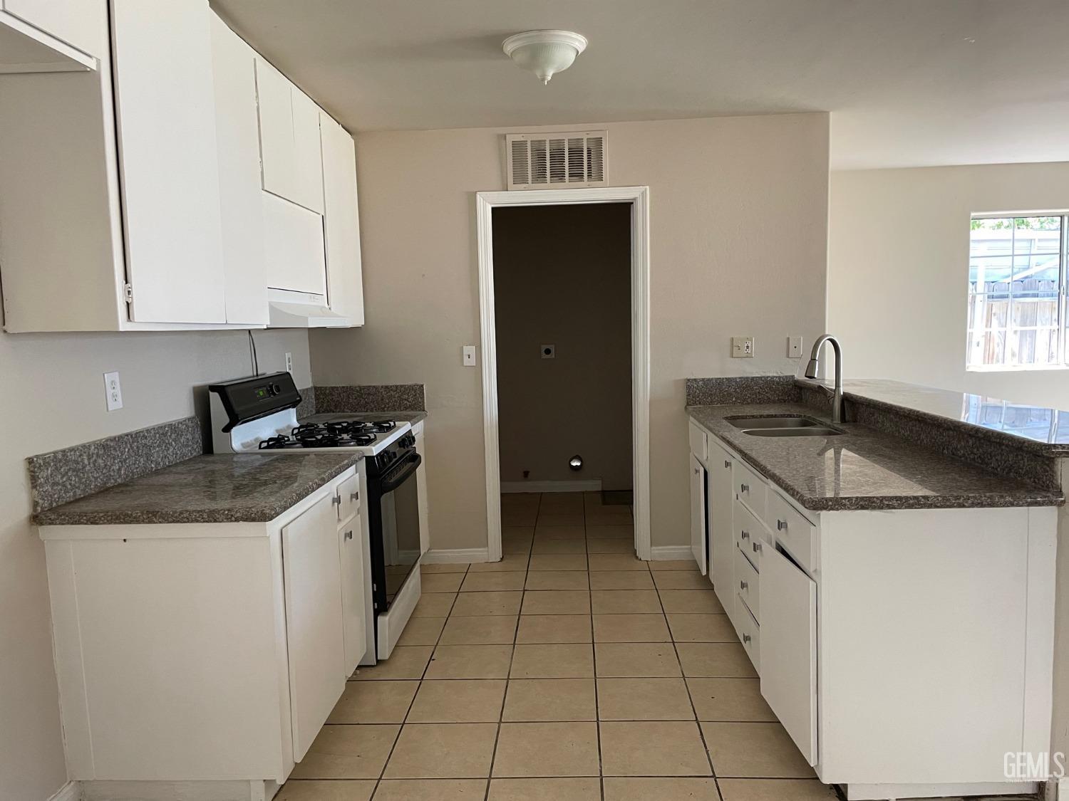 Undisclosed Address Bakersfield, CA 93307 - Photo 8 of 20 a kitchen with granite countertop a sink and a stove top oven