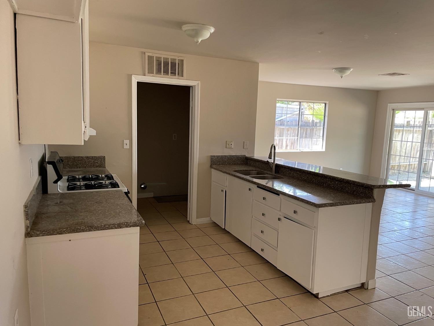 Undisclosed Address Bakersfield, CA 93307 - Photo 9 of 20 a kitchen with granite countertop a stove and a sink