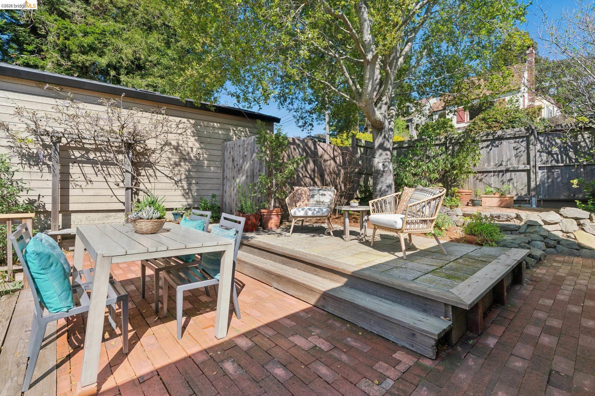 890 Keeler Avenue Berkeley, CA 94708 - Photo 33 of 39 a view of a patio with table and chairs and potted plants with wooden floor and fence