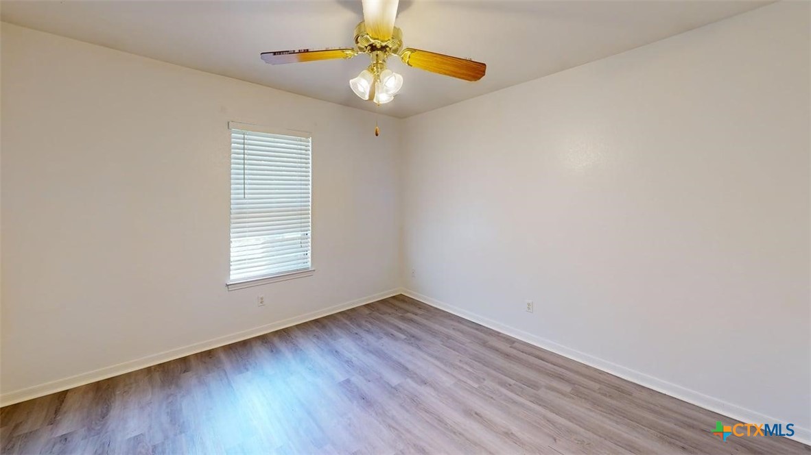 204 West Truman Avenue, Unit D Copperas Cove, TX 76522 - Photo 5 of 12 an empty room with a window and wooden floor