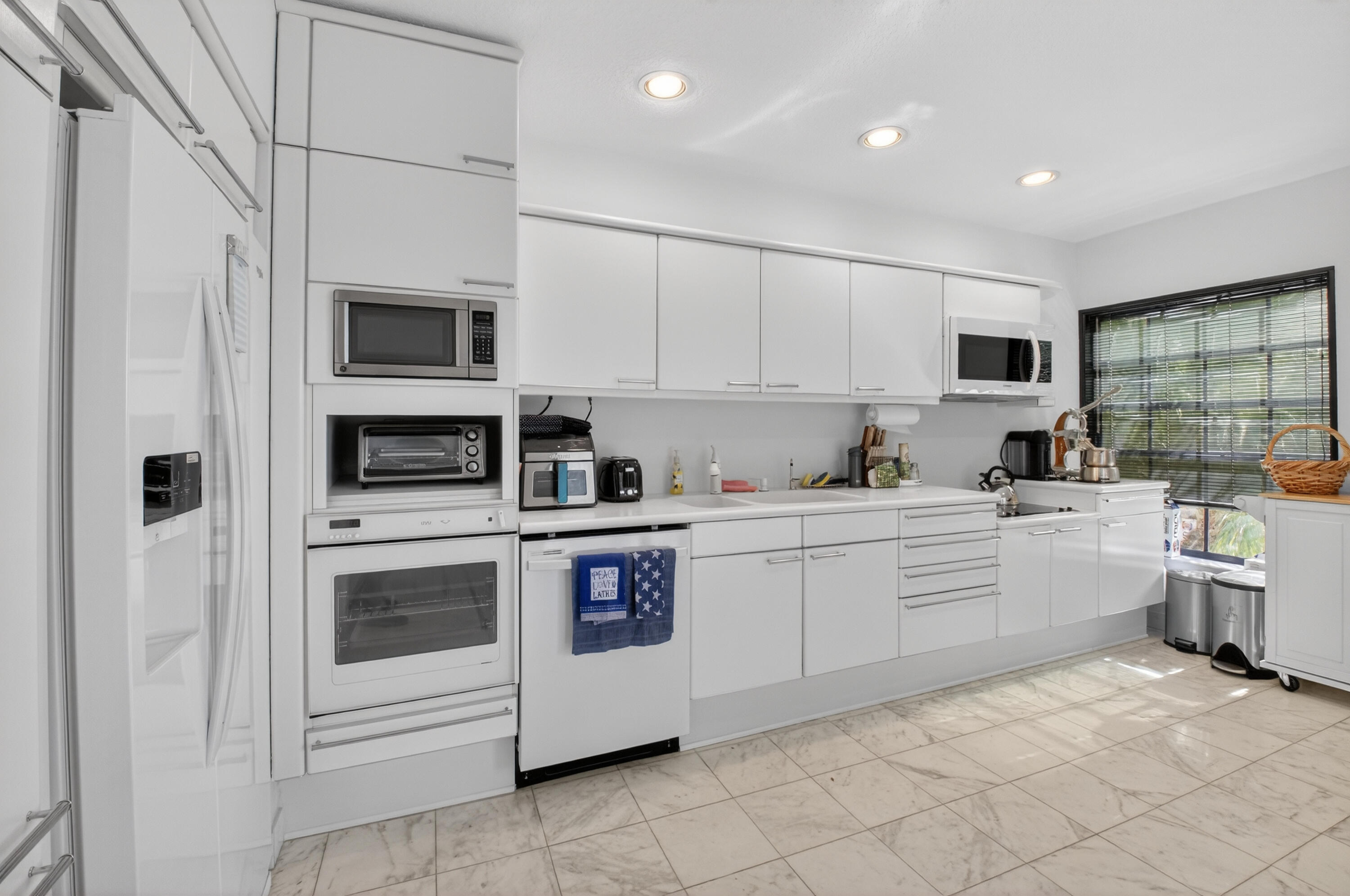 7369 Orangewood Lane, Unit 307 Boca Raton, FL 33433 - Photo 11 of 37 a kitchen with white cabinets stainless steel appliances and sink