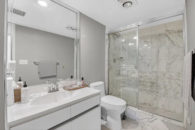 a bathroom with a sink a toilet and shower