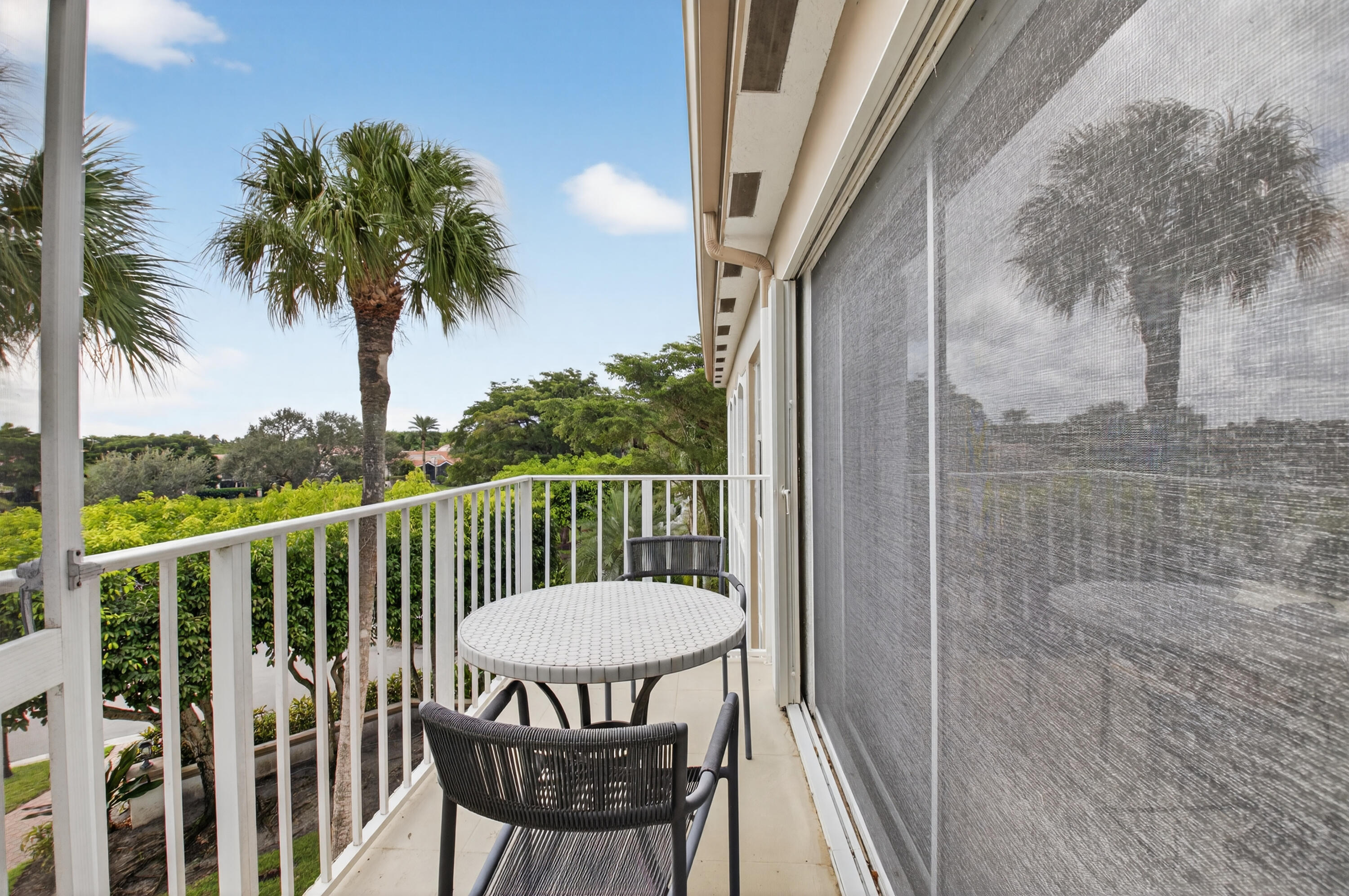 7369 Orangewood Lane, Unit 307 Boca Raton, FL 33433 - Photo 27 of 37 a view of a balcony with wooden floor and outdoor seating