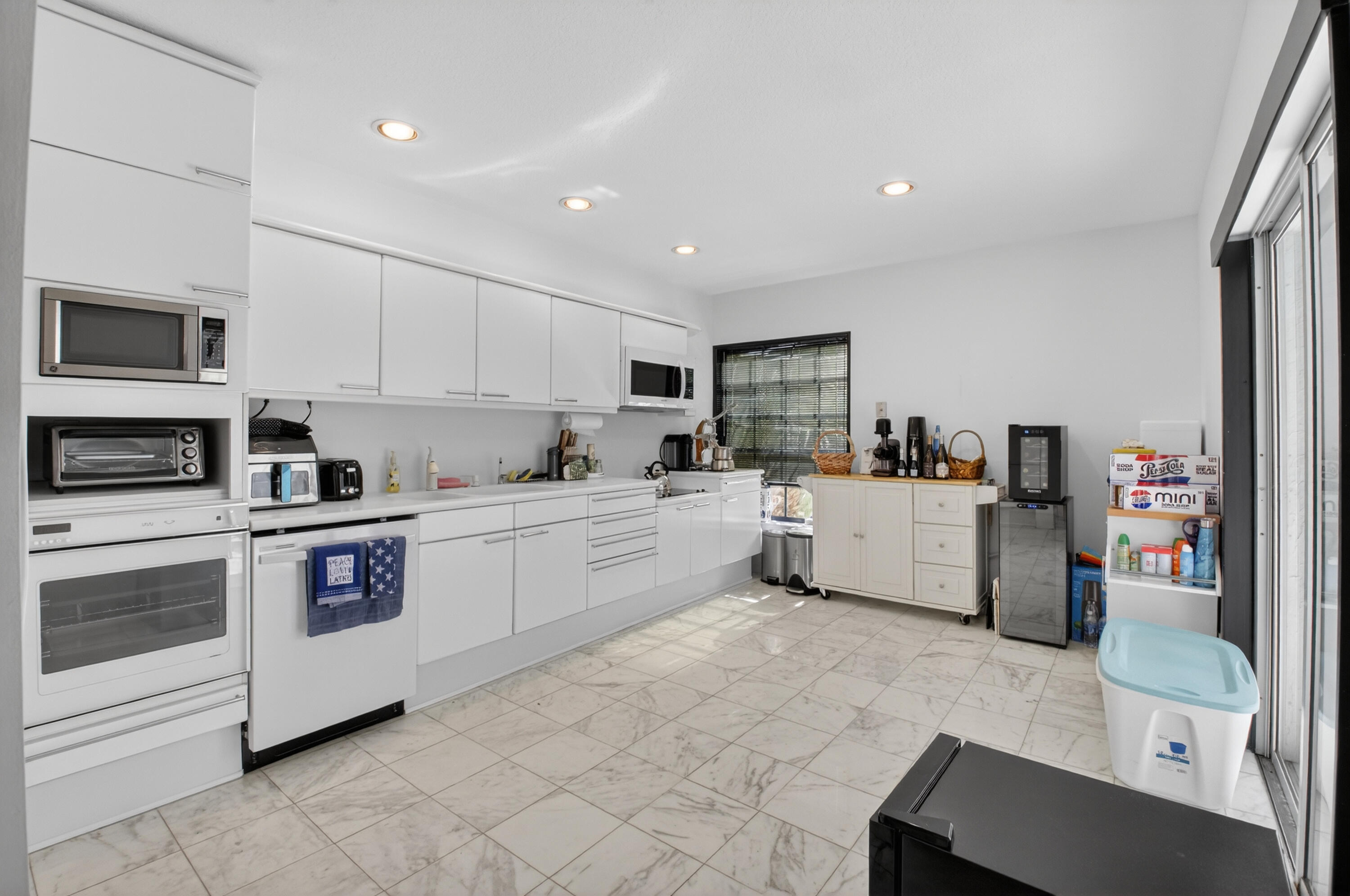 7369 Orangewood Lane, Unit 307 Boca Raton, FL 33433 - Photo 10 of 37 a kitchen with stainless steel appliances a refrigerator sink and microwave