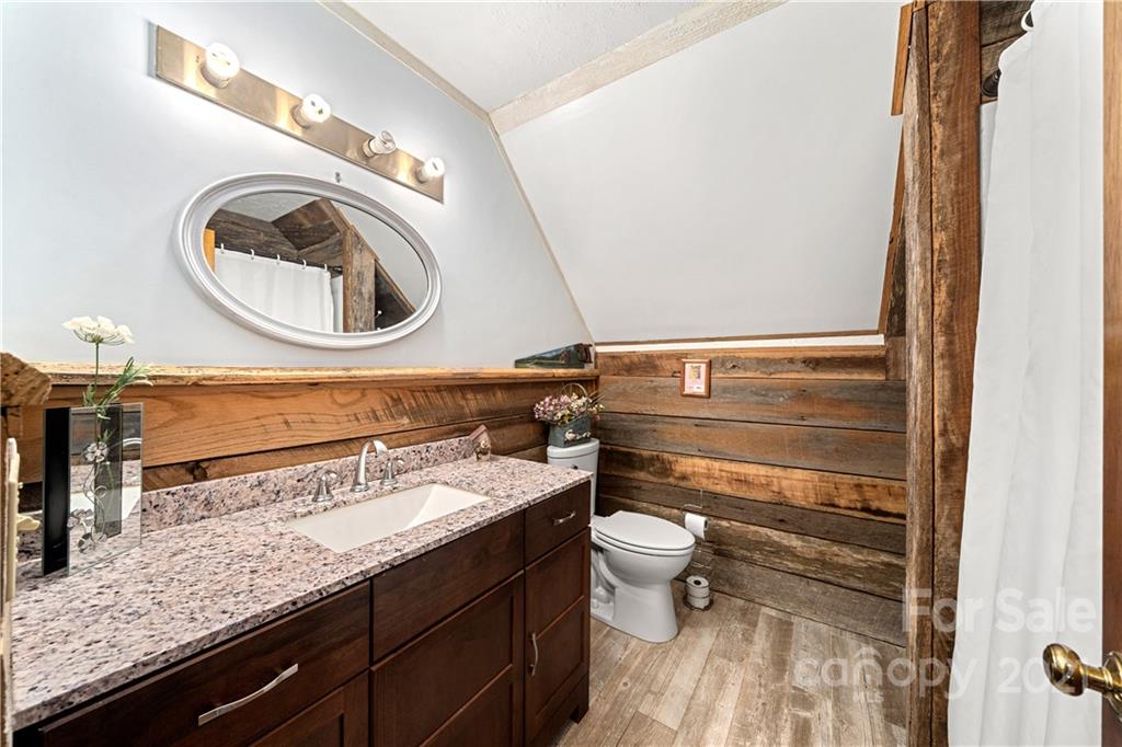 1595 Kitchens Branch Road Sylva, NC 28779 - Photo 28 of 45 a bathroom with a granite countertop toilet sink and mirror