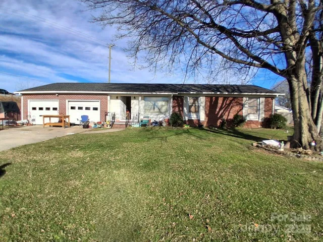 a view of a house with backyard and trees