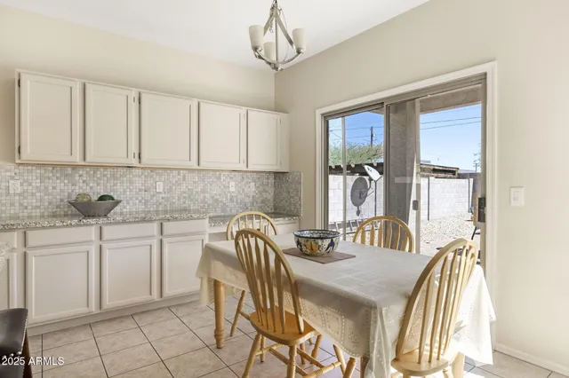 a kitchen with stainless steel appliances granite countertop a stove top oven a refrigerator a sink and chairs