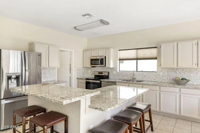 a kitchen with granite countertop a sink stove and microwave