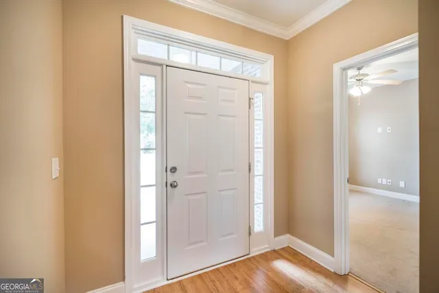 an empty room with windows and chandelier fan
