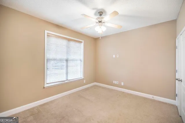 an empty room with closet and fan