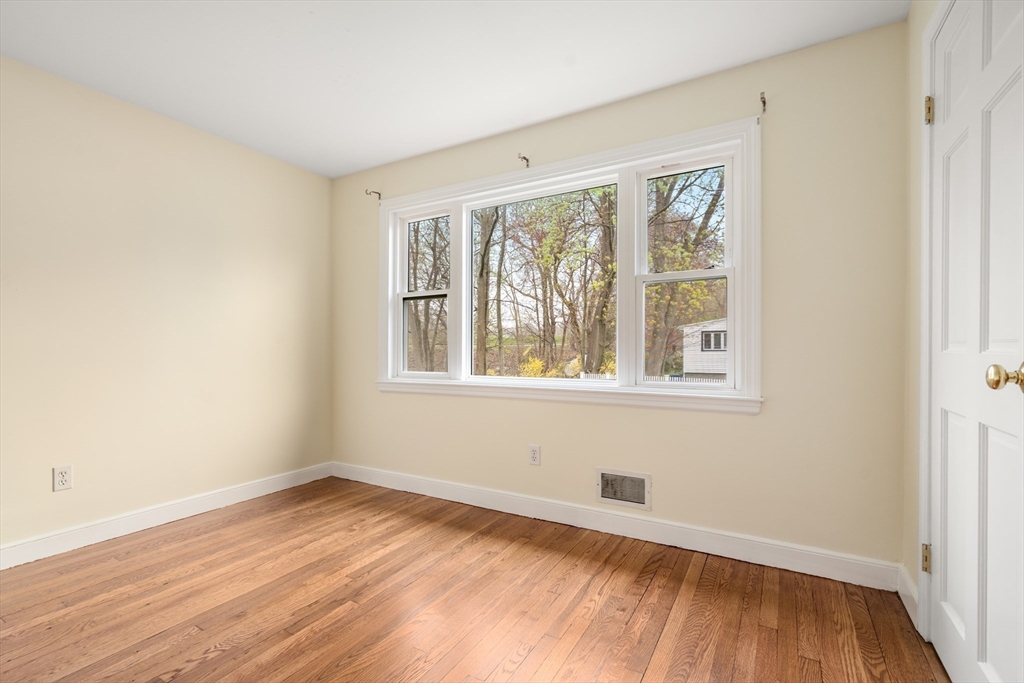 125 Lyman Road Milton, MA 02186 - Photo 16 of 25 an empty room with wooden floor and windows