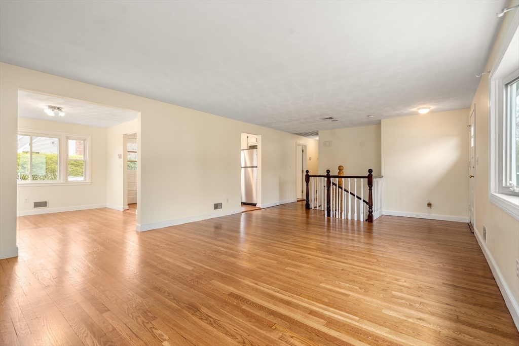 125 Lyman Road Milton, MA 02186 - Photo 3 of 25 a view of an empty room with wooden floor and a window