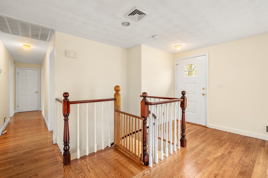 125 Lyman Road Milton, MA 02186 - Photo 4 of 25 a view of a hallway with wooden floor and stairs