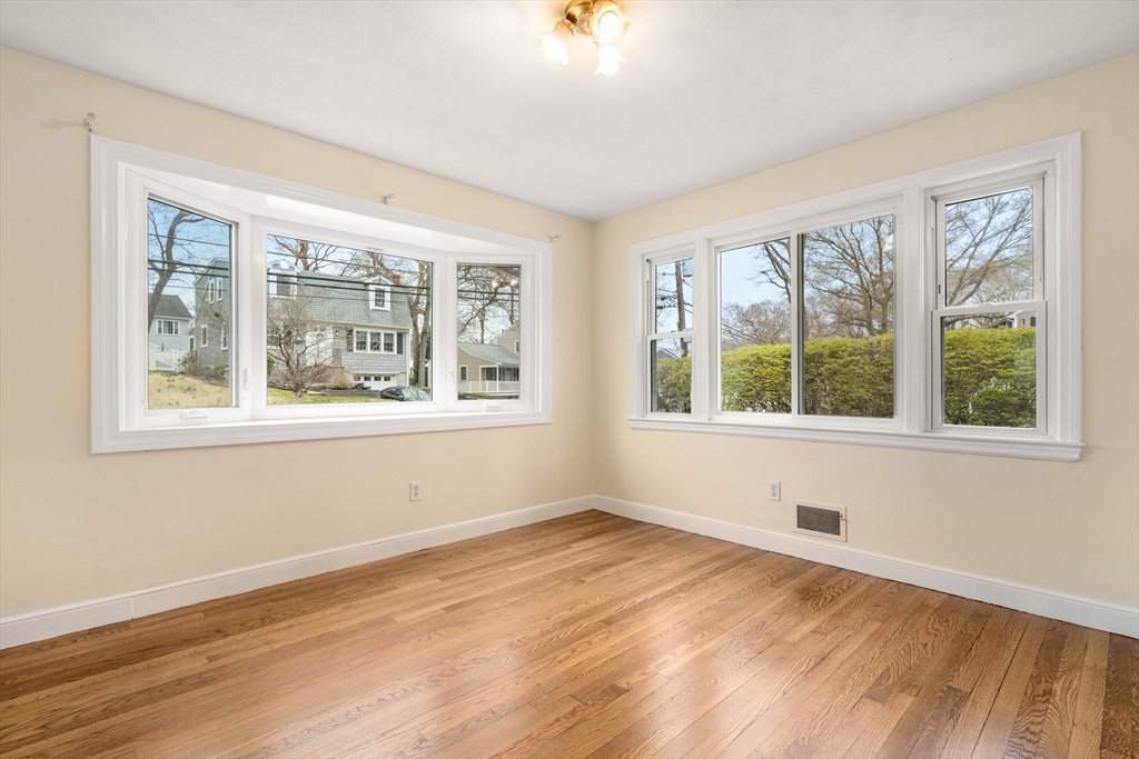125 Lyman Road Milton, MA 02186 - Photo 7 of 25 a view of an empty room with wooden floor and a window