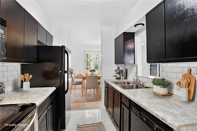 a kitchen with stainless steel appliances kitchen island granite countertop a sink dishwasher stove and refrigerator with wooden floor