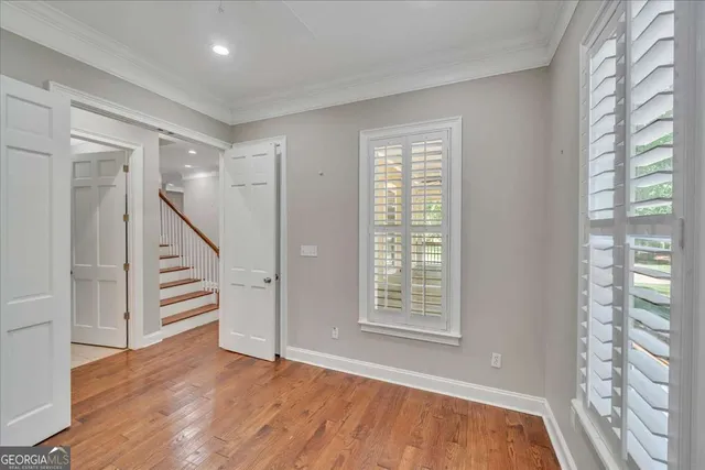 a view of an empty room with a window and wooden floor