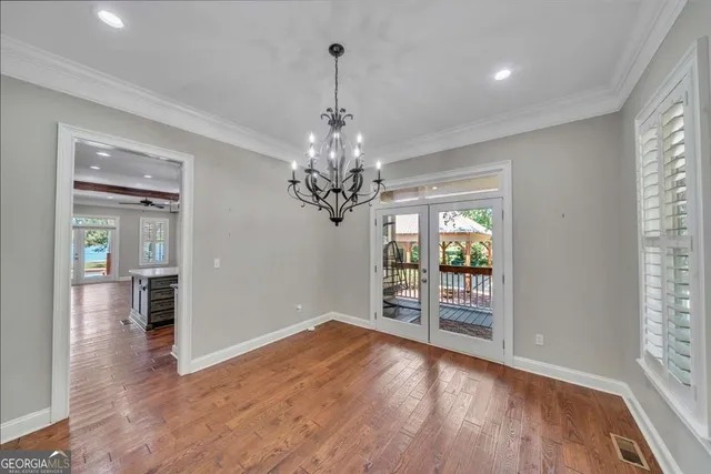 a view of empty room with wooden floor and ceiling fan