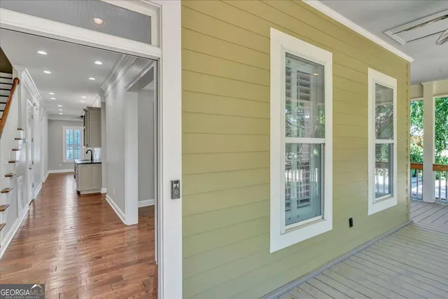 a view of a white house with a small yard and potted plants