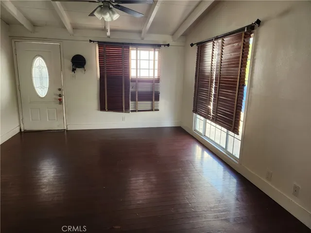 a view of a room with wooden floor and a window