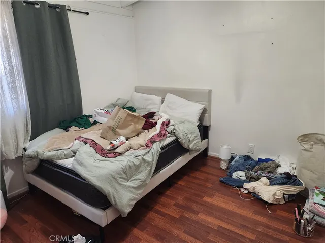 a bed sitting in a bedroom next to a window with chair