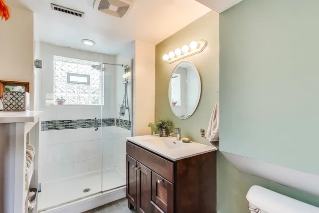 a bathroom with a sink mirror vanity and toilet