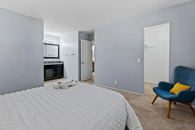 a bedroom with a bed a chair and a fireplace