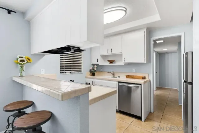 a kitchen with a sink a stove cabinets and a window