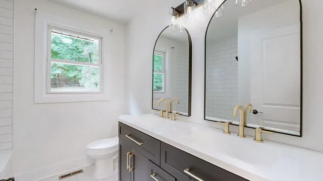 a bathroom with a double vanity sink toilet and a mirror