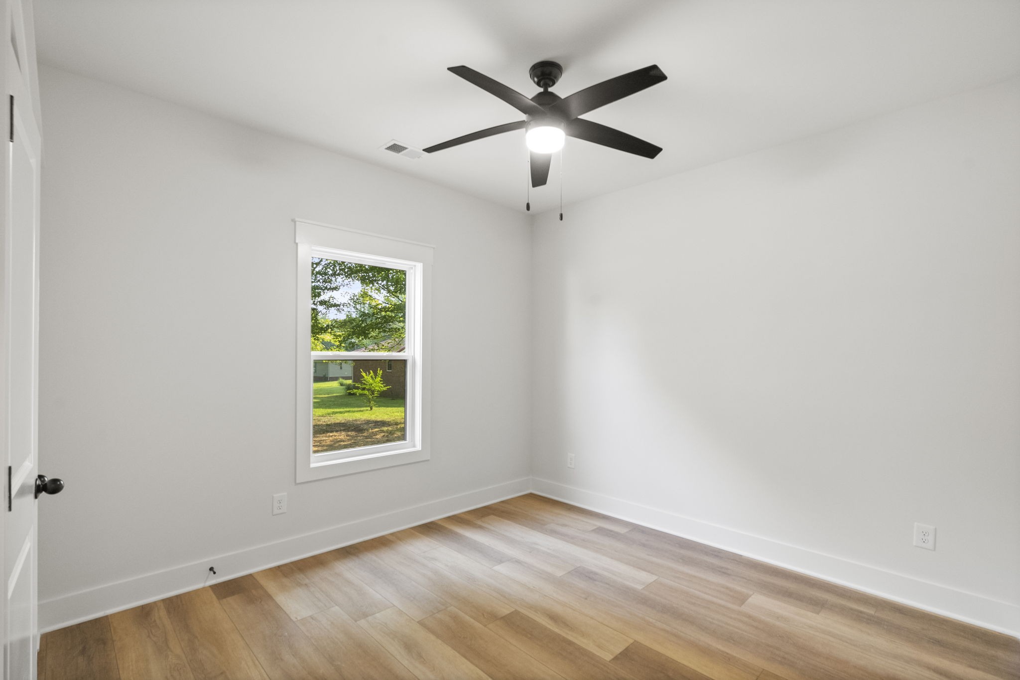 204 Point Road Portland, TN 37148 - Photo 19 of 51 an empty room with wooden floor ceiling fan and windows