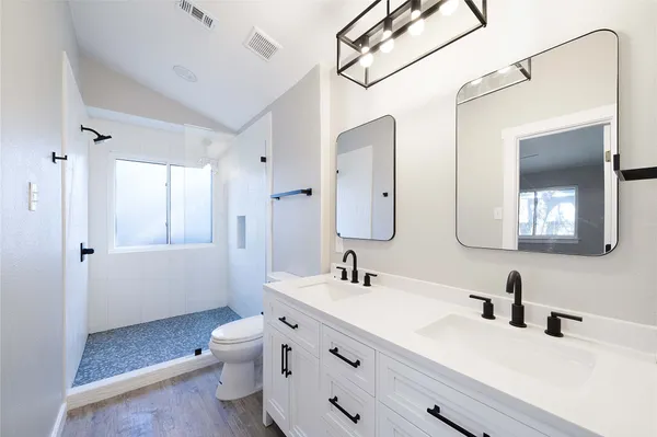 a bathroom with a sink a toilet and shower