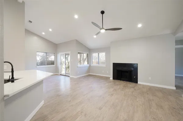 a view of an empty room with a fireplace and a window