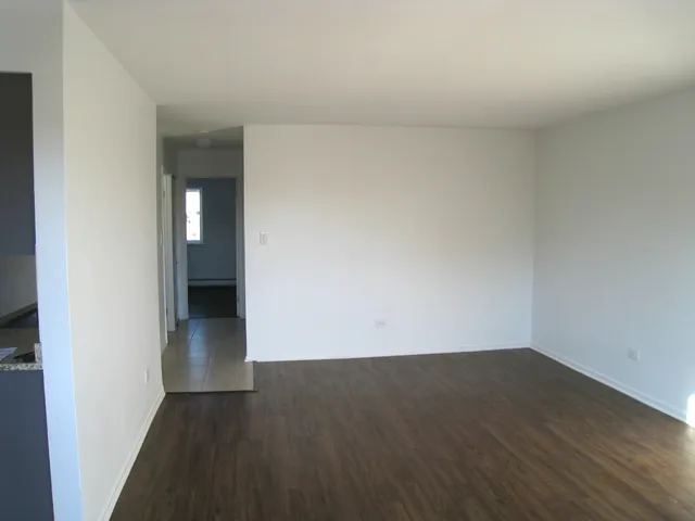 an empty room with wooden floor and entrance