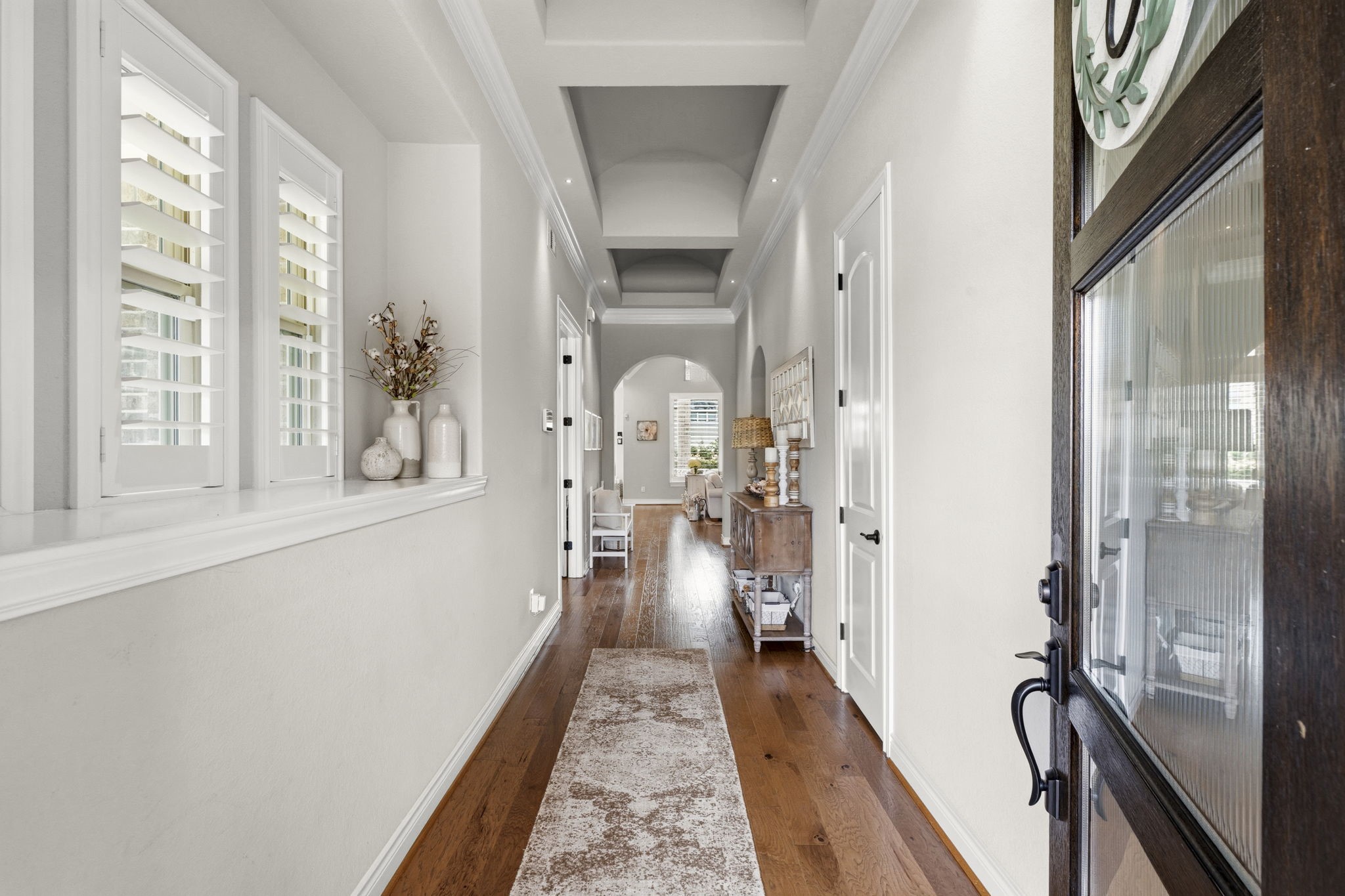 14012 Beartooth Bend Trail Conroe, TX 77384 - Photo 7 of 50 Step through the foyer and into a breathtaking introduction to the home, where timeless architectural details create an immediate sense of sophistication and scale. Arched passageways, double crown molding, and a wall of windows frame the space with refined craftsmanship.