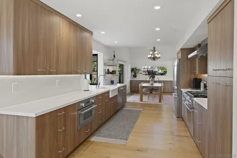 a large kitchen with stainless steel appliances a large counter top a stove and a refrigerator