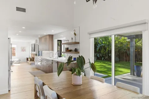 a kitchen with a table chairs and wooden floor