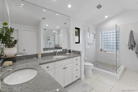 a bathroom with a granite countertop sink mirror and shower