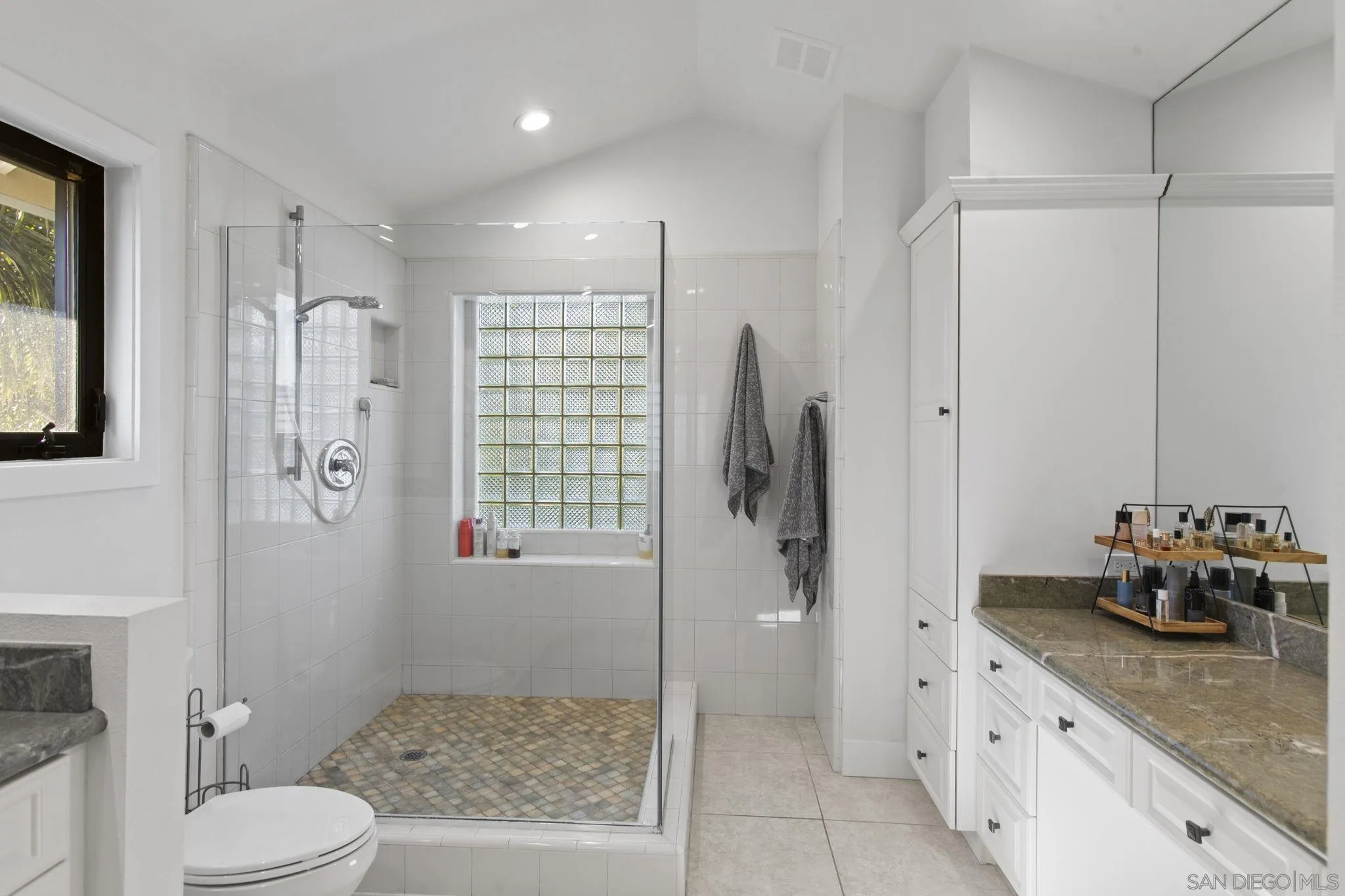 3942 Avenida Brisa Rancho Santa Fe, CA 92091 - Photo 32 of 47 a bathroom with a granite countertop sink a mirror a toilet and shower