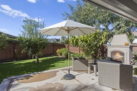 a view of a patio with a table and chairs under an umbrella